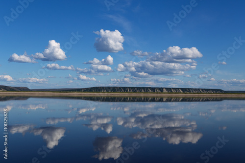 Reflection of clouds in the river and the distant shore. Lena river. Yakutia. Russia.