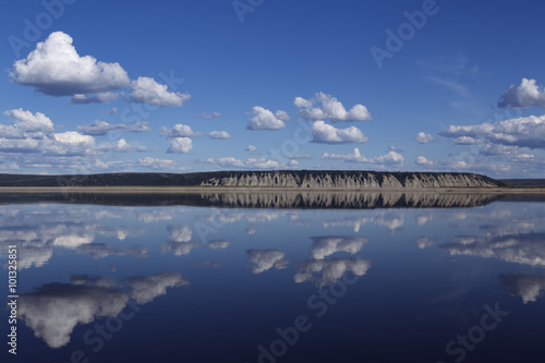 Reflection of clouds in the river and the distant shore. Lena river. Yakutia. Russia.