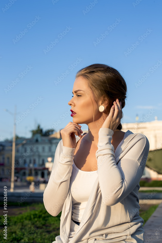 Pretty young woman posing outdoors on urban background Pretty young woman posing outdoors on urban background