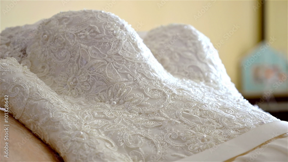 Bride's dress lying on a bed Bride's dress lying on a bed