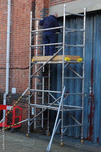 A painter and decorator working from a scaffold tower