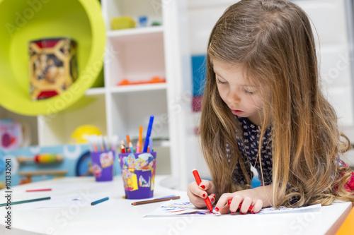 Little girl drawing at playroom