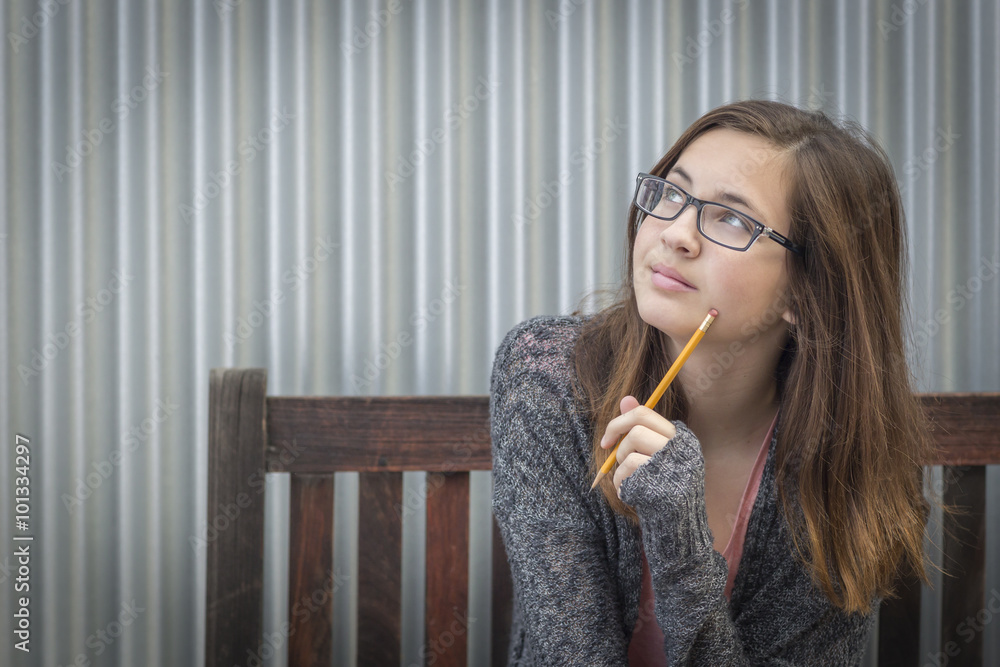 Young Daydreaming Female Student With Pencil Looking to the Side Young Daydreaming Female Student With Pencil Looking to the Side