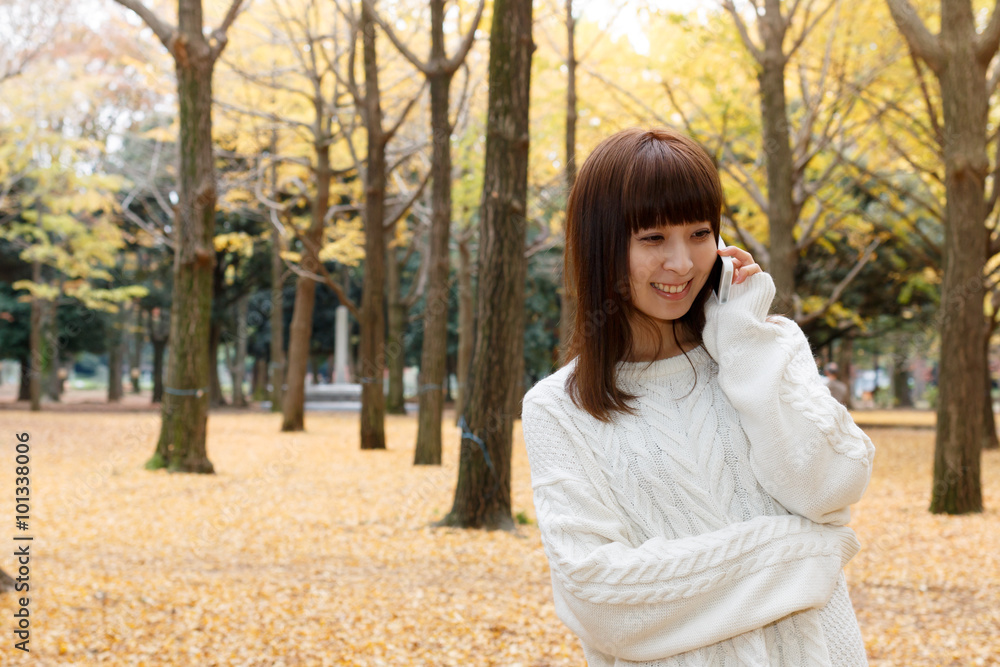 公園で電話している女性 公園で電話している女性