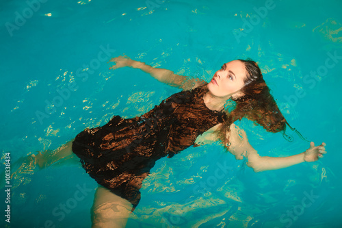 Woman dreaming relaxing in swimming pool water.