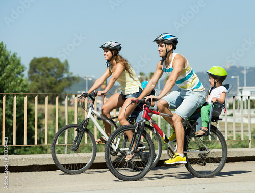 Family of four cycling on street