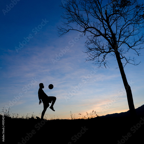 Boys play soccer silhouette