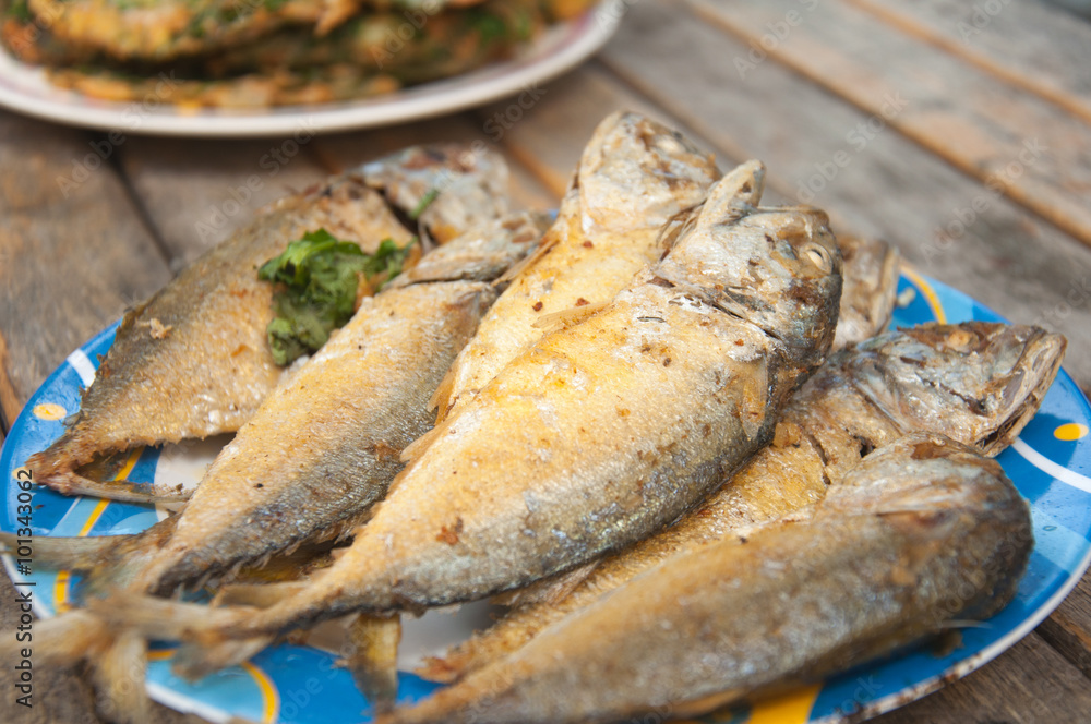 fried mackerel fish in blue dish on wood table fried mackerel fish in blue dish on wood table