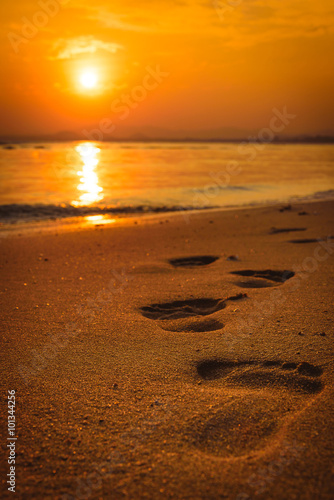 Footprints on the beach at sunset. Selected focus.