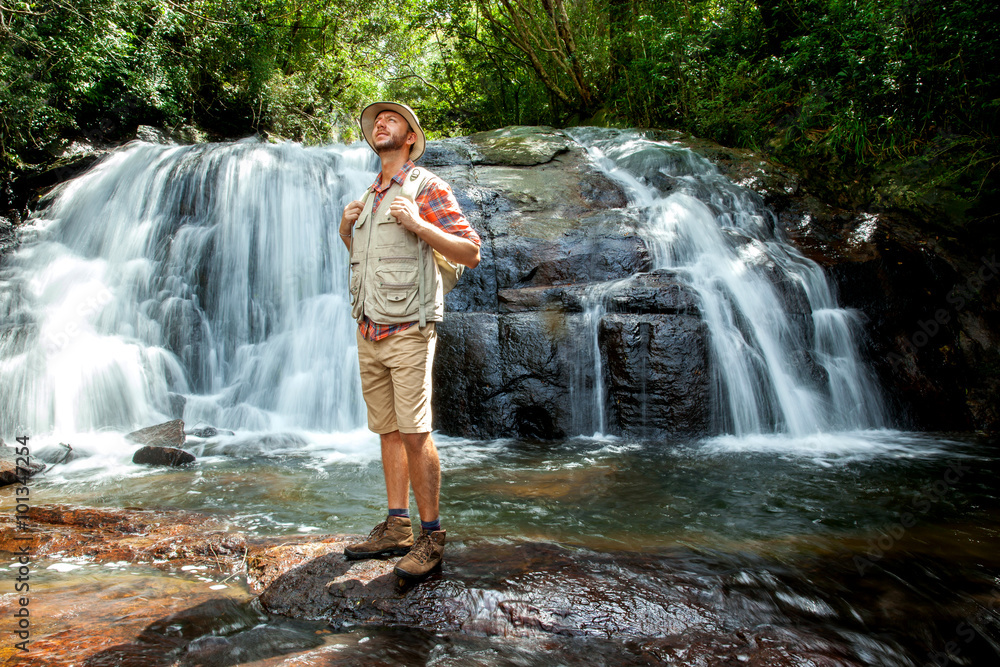 Hiker standing in front of a waterfall Hiker standing in front of a waterfall