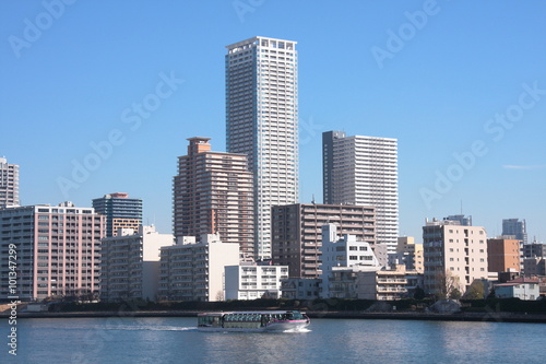 都会の川辺の光景、青空と高層ビル群