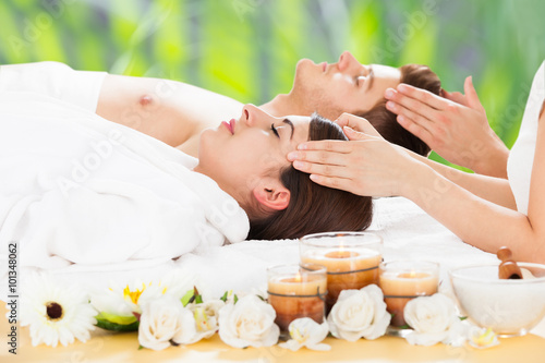 Relaxed Couple Receiving Head Massage At Spa