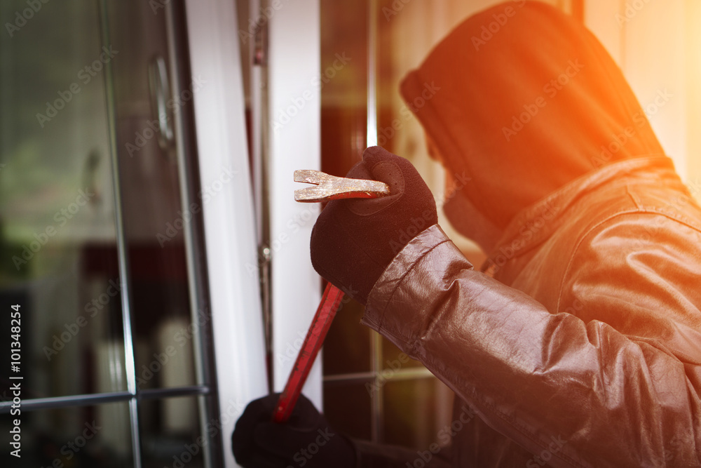 Burglar breaking in a house - obrazy, fototapety, plakaty 