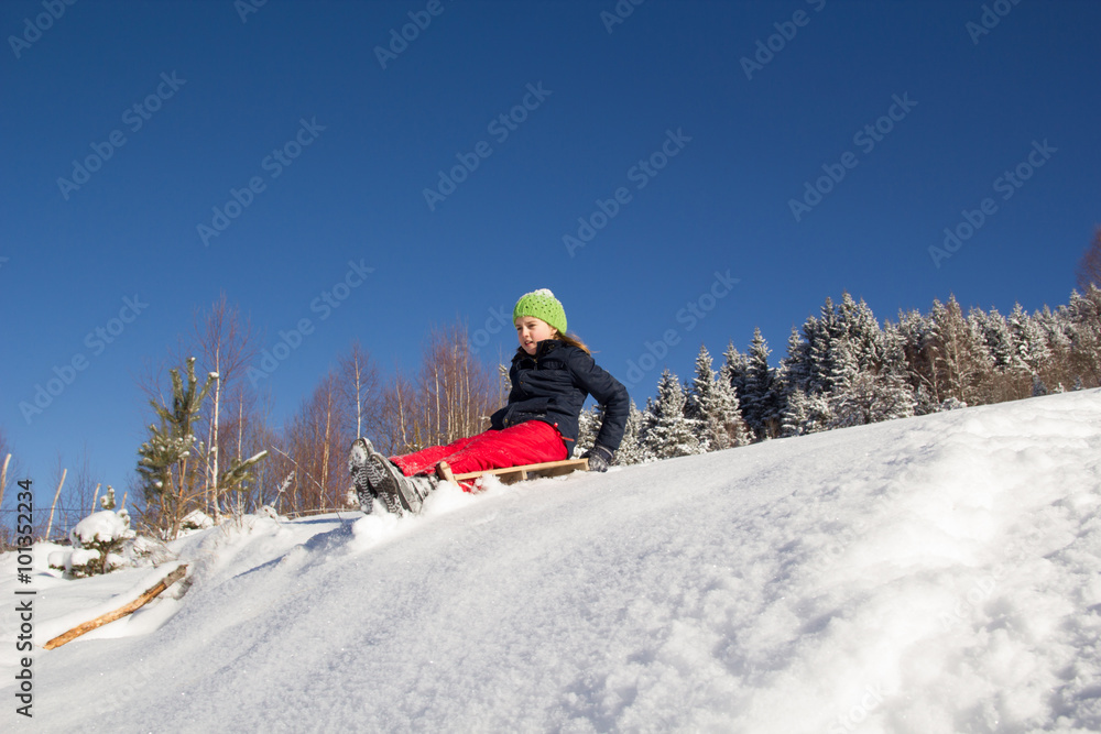 Little girl on sleigh. Sledging on mountain. Winter time
