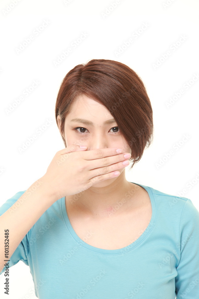 young Japanese woman making the speak no evil gesture young Japanese woman making the speak no evil gesture