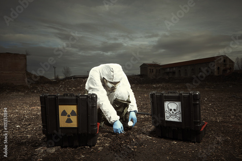Foto Solgier in gas mas checking contamination of soil