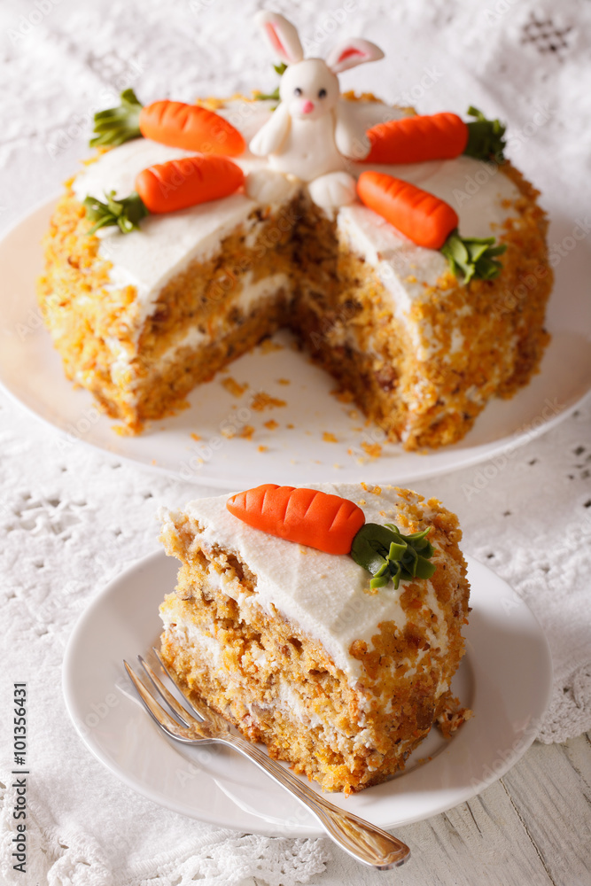 Beautiful cake decorated with bunny and carrot and slice close-up. vertical

