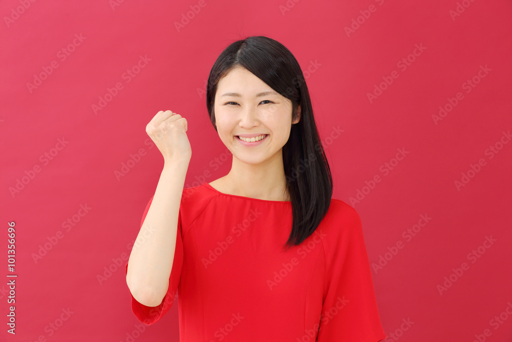 ガッツポーズ・若い女性・赤背景 ガッツポーズ・若い女性・赤背景