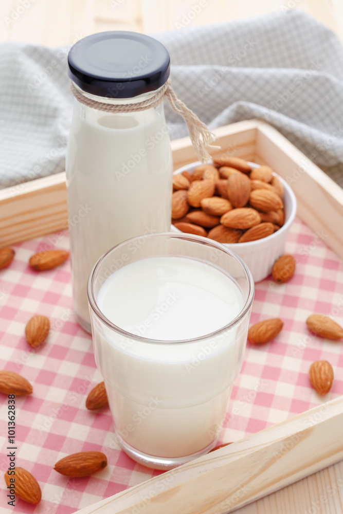 Almond milk in glass and bottle with almonds Almond milk in glass and bottle with almonds