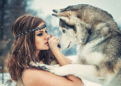 Friendship/ Delightful girl plays with a Siberian Husky in snowy woods