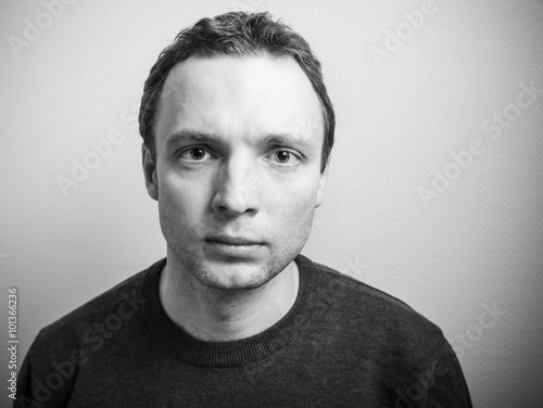 Young serious man studio portrait, black and white