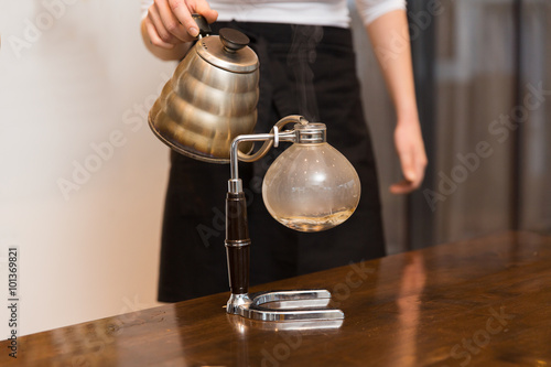 close up of woman with siphon coffee maker and pot