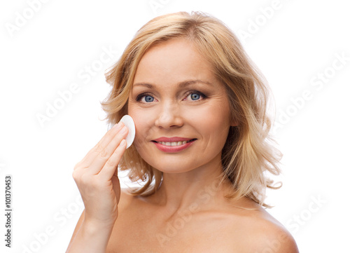 happy woman cleaning face with cotton pad