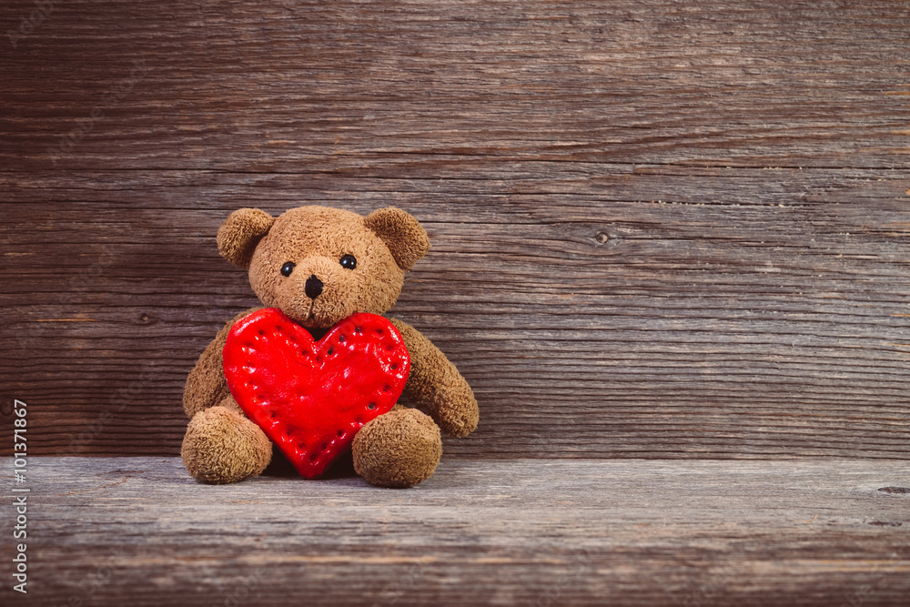 Teddy bear with heart sitting on old wood background. Stock Photo ...