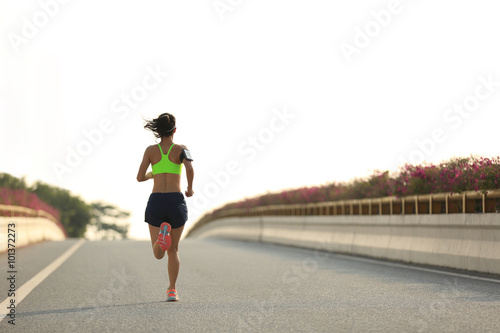 young fitness woman runner running at city road