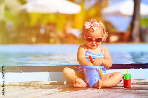 cute little girl playing in swimming pool at beach