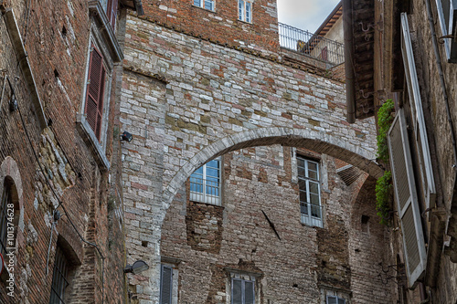 Ancient Etruscan arch made of lime and brick between the medieval houses