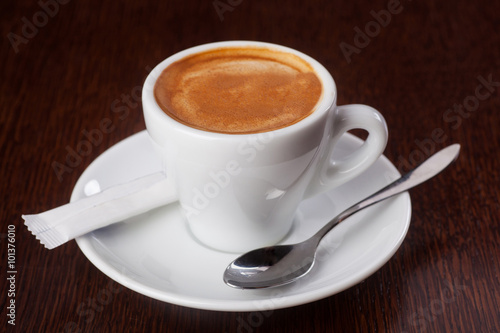 Cup of espresso with crema on wooden table. Shallow dof