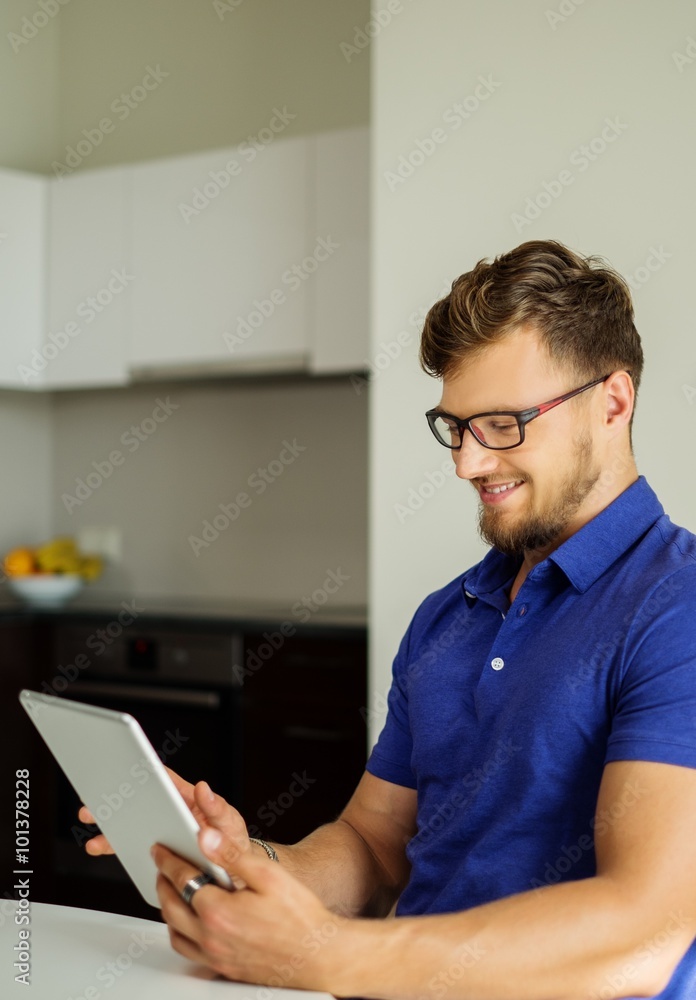 Handsome man using tablet pc at home Handsome man using tablet pc at home
