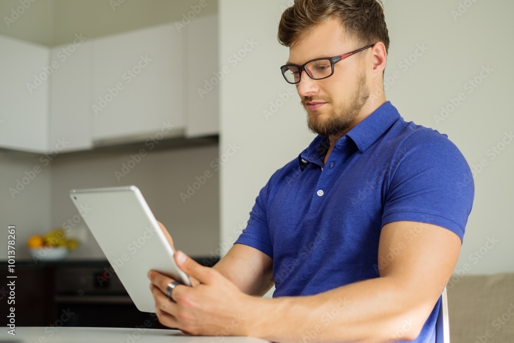 Handsome man using tablet pc at home Handsome man using tablet pc at home