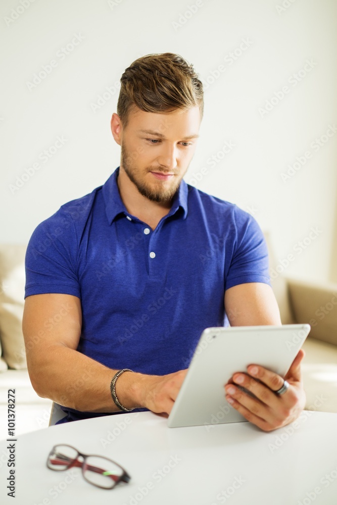 Handsome man using tablet pc at home Handsome man using tablet pc at home