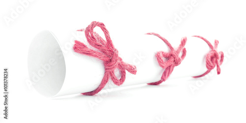 White letter tube tied with rope, three red knots isolated
