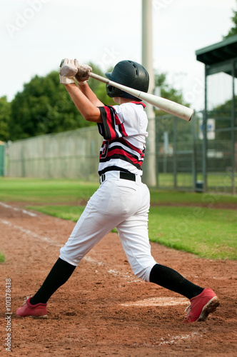Youth baseball boy swinging bat