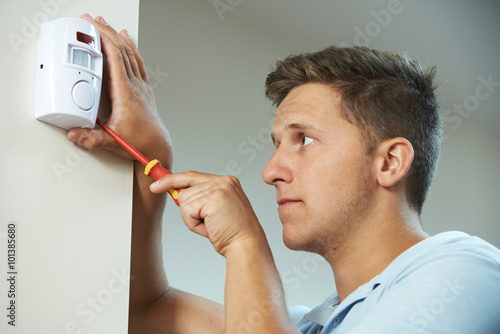 Security Consultant Fitting Burglar Alarm Sensor In Room photo