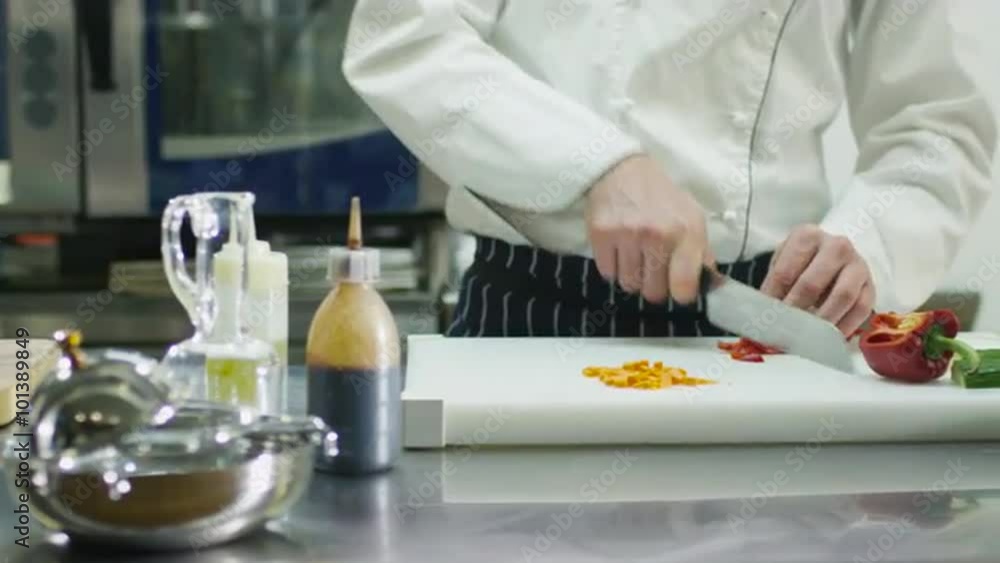 Professional chef in a commercial kitchen in a restaurant or hotel is slicing green vegetables. Shot on RED Cinema Camera. Professional chef in a commercial kitchen in a restaurant or hotel is slicing green vegetables. Shot on RED Cinema Camera.