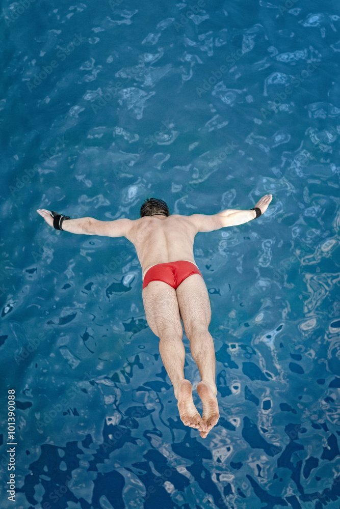 Professional high diver flying towards the water, shot from above