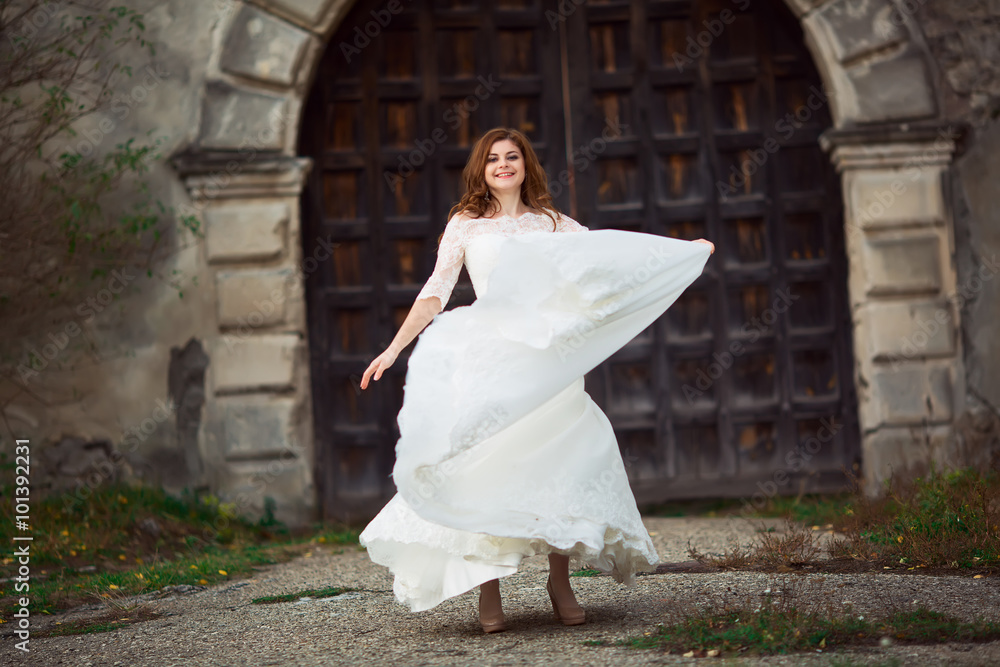 Beautiful woman in a white wedding dress dancing