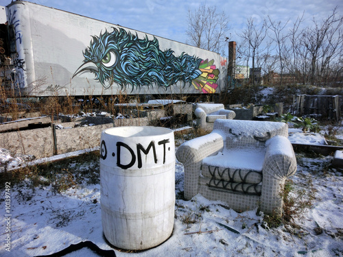 Mean looking abandoned chair in the snow with barrel and graffiti - landscape photo