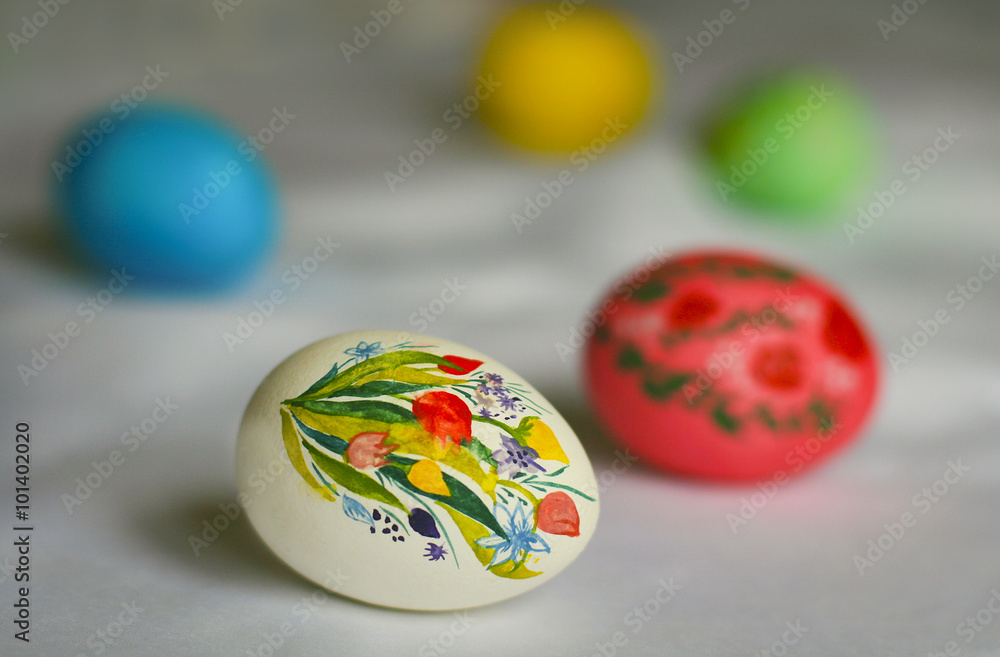 Расписные пасхальные яйца: белое с букетом тюльпанов, красное, голубое, зеленое и желтое