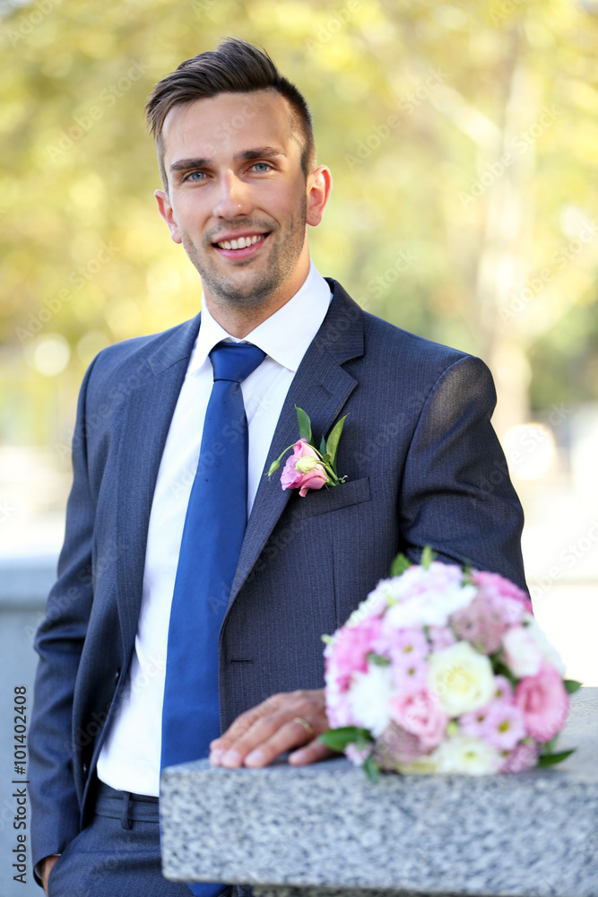 Groom holding wedding bouquet outdoors Groom holding wedding bouquet outdoors