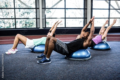 Fit people doing exercise with bosu ball photo