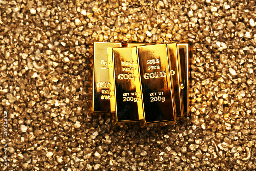 Fotografie Gold bars on nugget grains background, close-up