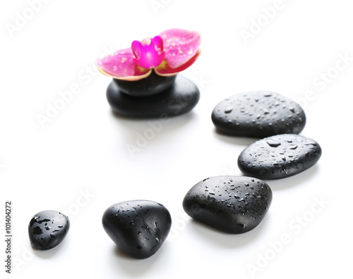 Black spa stones and orchids isolated on white