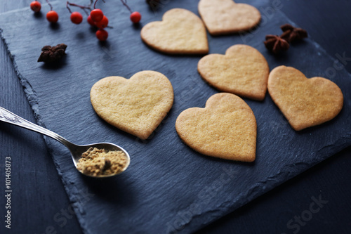 Heart shaped biscuits with ash berries on a mat