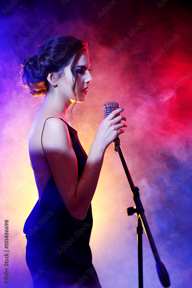 Young beautiful woman singing in colourful smoke, close up Young beautiful woman singing in colourful smoke, close up