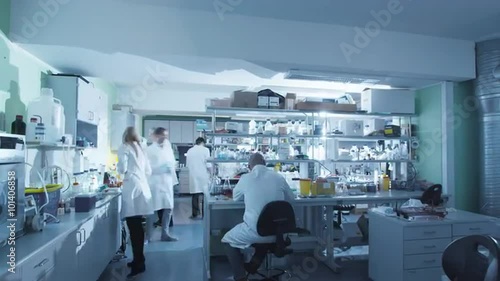 Timelapse footage of a team of scientists in white coats that are working in a modern laboratory. Shot on RED Cinema Camera. photo